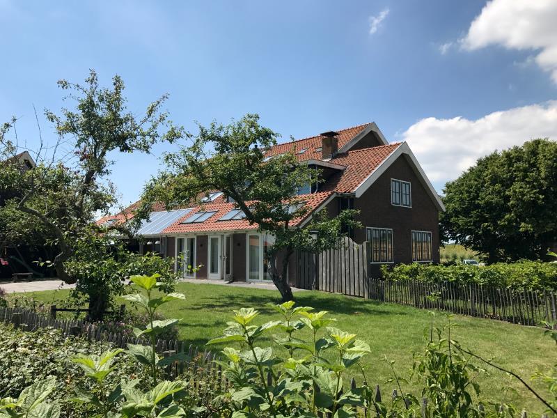 buitenaanzicht vakantieboerderij de bietenhaven omringt met gras en bomen